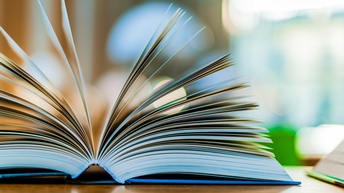 Ein aufgeklapptes Buch auf einem Tisch