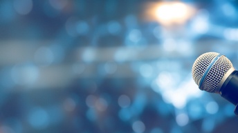 Nahaufnahme eines Mikrofons vor einem Hintergrund in der Unschärfe