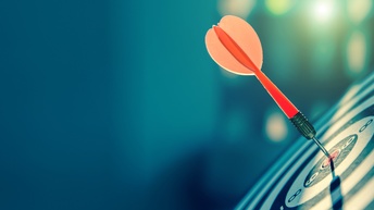 Roter Dartpfeil steckt in einer Zielscheibe