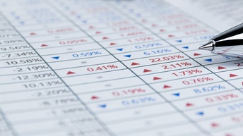 Detailansicht einer Kugelschreiberspitze, die auf Unterlage mit verschiedenen Prozentzahlen liegt