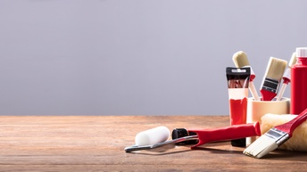Diverse Malerutensilien auf einem Holztisch