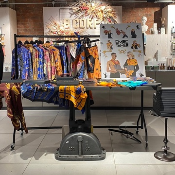 Frau und Mann stehen in Modegeschäft und schauen in die Kamera