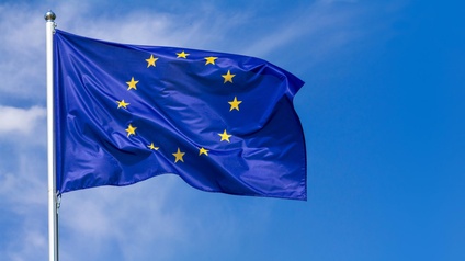 Flagge der Europäischen Union im Wind wehend, im Hintergrund blauer Himmel