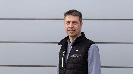 Ein Mann, der vor einem Tor steht.