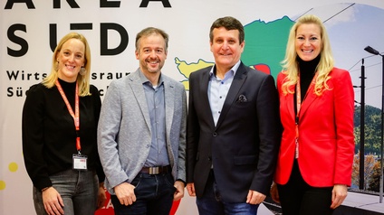 Gruppenfoto mit zwei Frauen und zwei Männern vor einer Wand mit der Aufschrift AREA SÜD