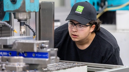 Der junge Goldmedaillengewinner bei der Arbeit vor einer großen Maschine