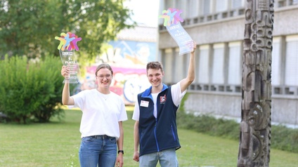 Das Siegerduo, das ihre Trophäen hoch hält