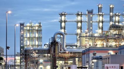 Beleuchtete Raffinerie in Dämmerlicht