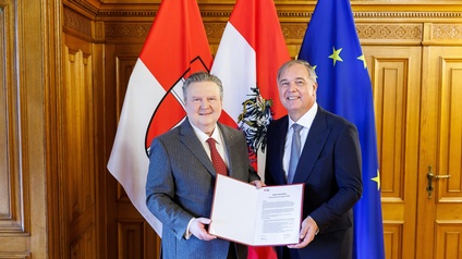 Ludwig und Ruck halten Vertrag - dahinter Wien-, Österreich- und Europa-Flagge 