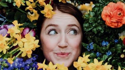Frau umkränzt von Blumen