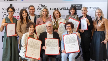 Gruppenbild mit mehreren Menschen, manche halten Urkunden in der Hand