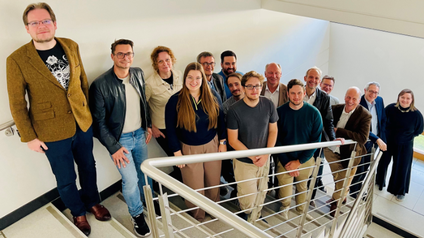 Gruppenfoto von Männern und Frauen auf einer Stiege