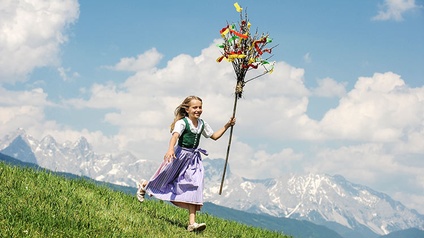 Salzburg, Altenmarkt-Zauchensee, Mädchen mit Palmbusch läuft eine Almwiese hinunter