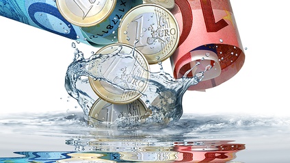 Euromünzen und -scheine in Wasser eintauchend
