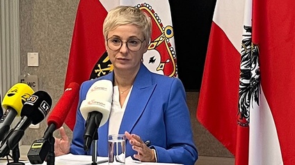 WKOÖ-Präsidentin Doris Hummer bei einem Medientermin. Im Vordergrund Mikrofone.