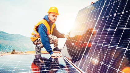 Mann montiert PV-Module auf dem Dach.