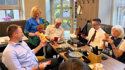 Maria Böhm zeigt Unternehmer:innen den Gewinnspielflyer