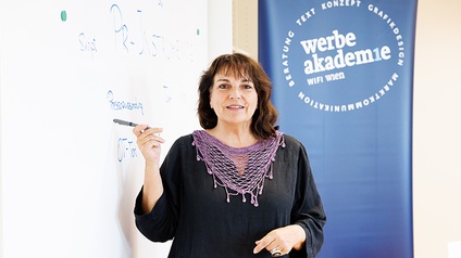 1 Frau mit Stift vor Whiteboard in der Werbe Akademie