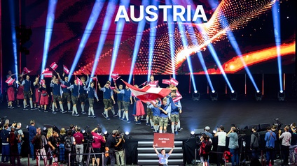 Teilnehmer:innen aus Österreich auf Bühne im Saal