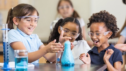Begeistert Mädchen mit Chemie-set in elementary science parlamentarische Bestuhlung - Stock-Fotografie