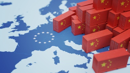 Verschiedene chinesische Miniaturcontainer in rot mit goldenen Sternen stehen auf einer Landkarte in blauen Farbtönen und Fokus auf EU
