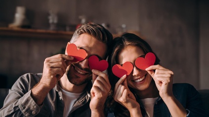 Glückliches Liebespaar am Valentinstag, das Herzformen hält