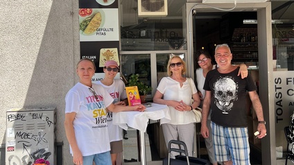 Vier Menschen vor einem Geschäftslokal