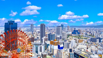 Landschaftsbild der belebten Gegend im Osten von Umeda im Bezirk Kita in der Präfektur Osaka mit zahlreichen modernen Wolkenkratzern und dem roten Riesenrad von Osaka. 