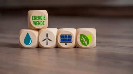 Mehrere Holzwürfel nebeneinander positioniert mit Symbolen zum Thema Nachhaltigkeit, oben auf ein weitere Holzwürfel mit dem Schriftzug Energiewende
