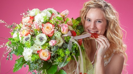 Blumenstrauß mit Herz und junge lächelnde Frau
