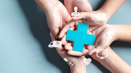 Drei Personen halten ihre geöffneten Hände übereinander 