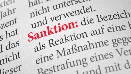 Nahaufnahme des Wortes Sanctions, das in roter Schrift gedruckt ist