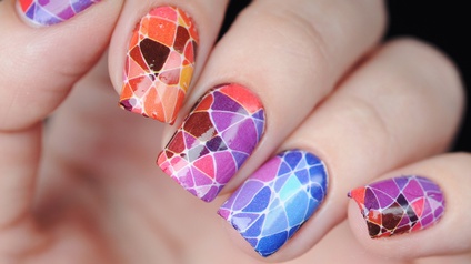 Nahaufnahme von Fingernägeln mit einem bunten, mosaikartigen Nageldesign.