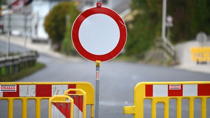 Eine Straßensperre an einer Baustelle: Ein Fahrverbotsschild zwischen gelben Baustellenzäunen.