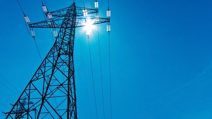 Ein Strommast mit Leitungen unter blauem Himmel