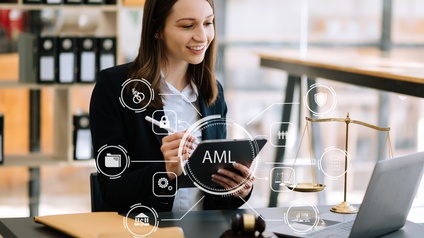 Eine Person sitzt an einem Tisch. In den Händen hält sie ein Tablet. Vor ihr ist ein aufgeklappter Laptop. Overlay diverser Symbole: Über der Person in der Mitte steht AML. Um AML sind verschiedene Symbole angelegt wie Zahnräder, eine Waage, ein Schloss.