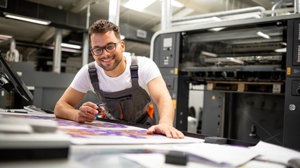 Person arbeitet in einer großen Druckerei