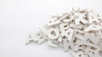 Ein Haufen weiß angemalter Buchstaben aus Holz