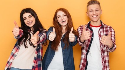 Drei junge Personen vor einem orangenen Hintergrund