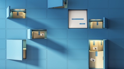 In einer blauen Wand sind mehrere Fächer, die teilweise geöffnet sind. Die Fächer haben unterschiedliche Formen und Größen. In den Fächern sind verschiedene Kartons