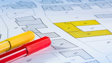 Imaginäre Katasterkarte mit Gebäuden, Grundstücksparzellen und unbebautem Grundstück