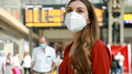 Person Mund-Nasenschutz in Terminalhalle stehend