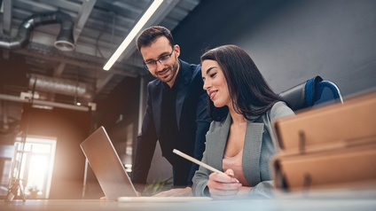 Zwei Personen über einem Laptop