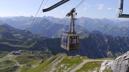 Eine Seilbahngondel in einer Berglandschaft.