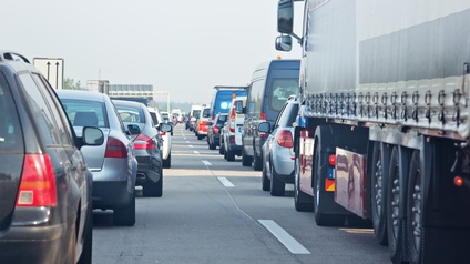 Auf einer mehrspurigen Straße stehen neben- und hintereinander viele unterschiedliche Fahrzeuge