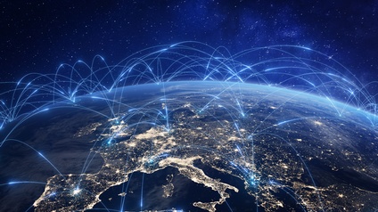 Satellitenaufnahme Europas bei Nacht mit vielen hellen Punkten, Wölbung der Erde ersichtlich. Über die Erdkugel verlaufen hellblaue Striche, die Länder und Erdteile miteinander verbinden