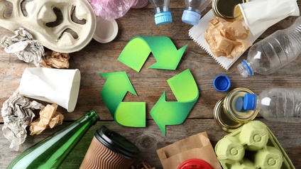 Recycling Konzept mit Recycling Symbol und unterschiedlichen Materialien auf einem Holzuntergrund, Topview
