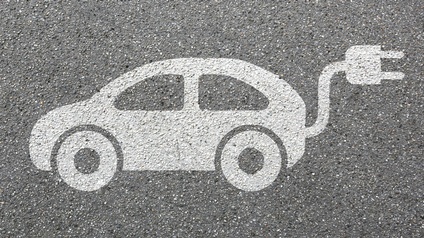 Auf asphaltiertem Untergrund ist das Symbol eines weißen Autos mit einem Stecker aus dem Kofferraum ragend.