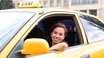 Lächelnde Frau aus Taxi blickend