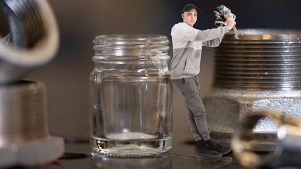 Lehrling lehnt an Glas